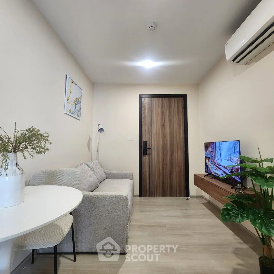 Modern living room with sleek furniture and stylish decor, featuring a cozy sofa and wall-mounted TV.