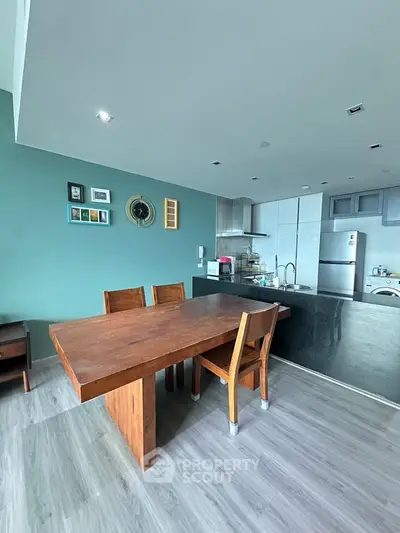 Modern kitchen with open layout and dining area, featuring sleek appliances and stylish decor.