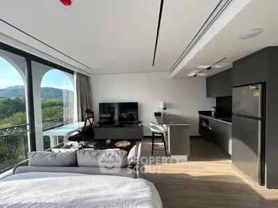 Modern studio apartment with open kitchen and scenic balcony view, featuring sleek furniture and natural light.