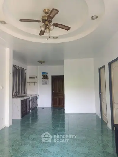 Spacious living room with ceiling fan and tiled floor