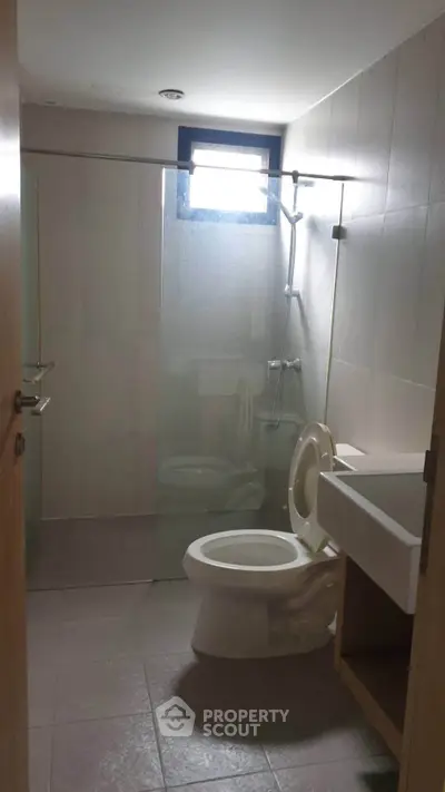Modern bathroom with glass shower and sleek fixtures in a contemporary apartment.