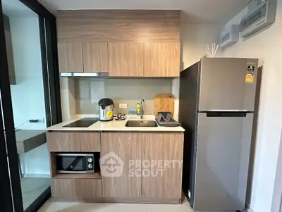 Modern compact kitchen with sleek wooden cabinets and stainless steel appliances