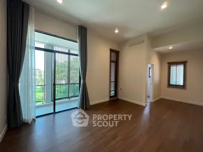 Spacious living room with large windows and balcony access
