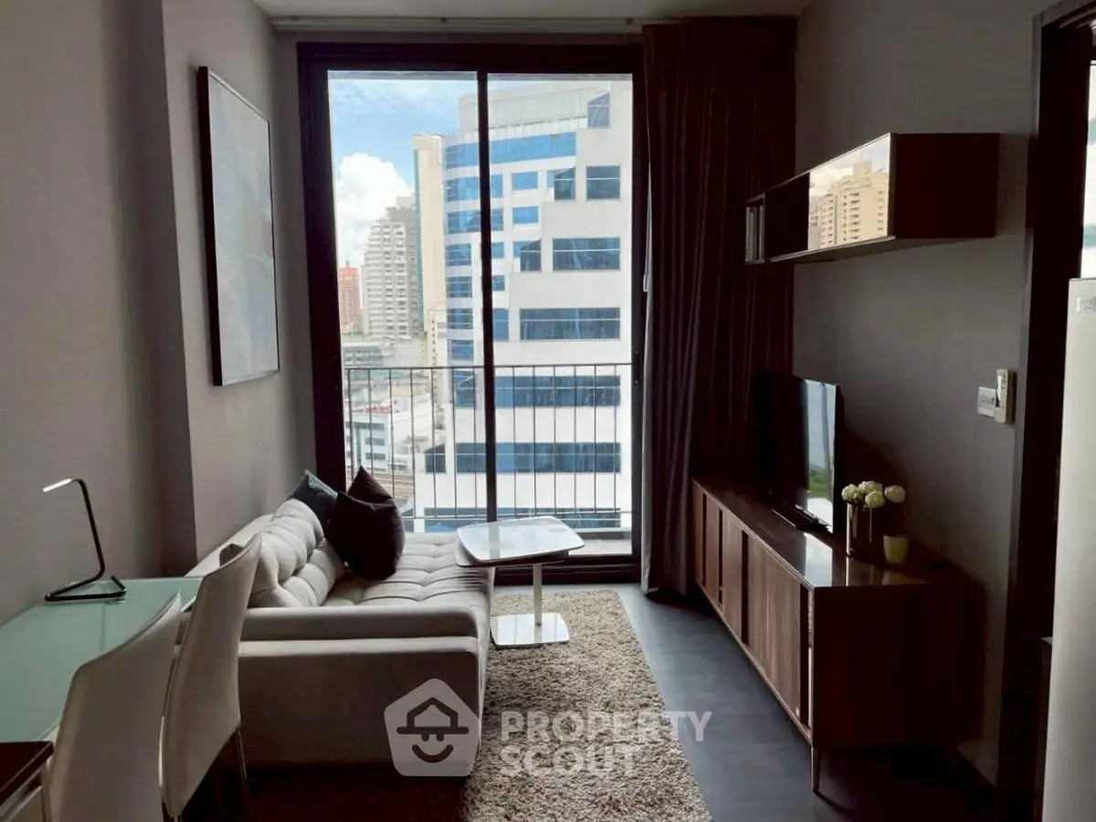 Modern living room with city view, featuring sleek furniture and large windows for natural light.