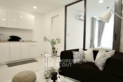 Modern living room with sleek black sofa and minimalist kitchen design