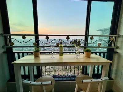 Stunning balcony view with cozy seating and cityscape backdrop, perfect for relaxation and entertaining.