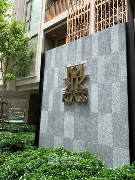 Modern building exterior with stylish facade and lush greenery at Klass residence.