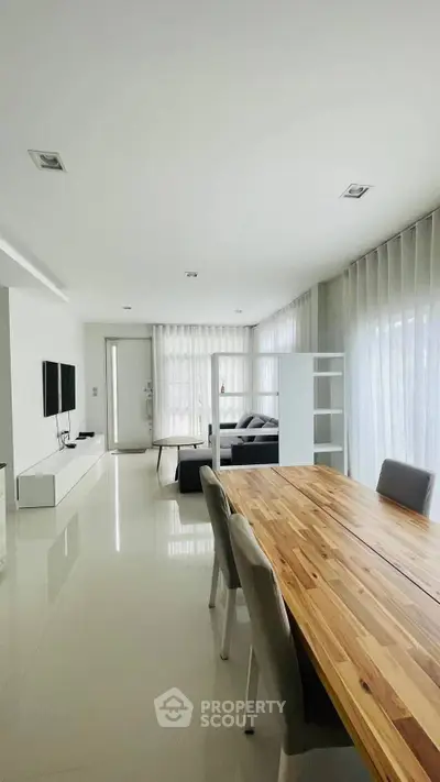 Spacious modern living room with elegant dining area and natural light