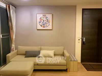 Cozy living room with modern beige sofa and stylish wall art, perfect for relaxation.