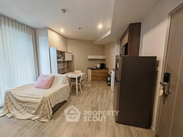 Modern open-plan living room with cozy sofa and sleek kitchen area.