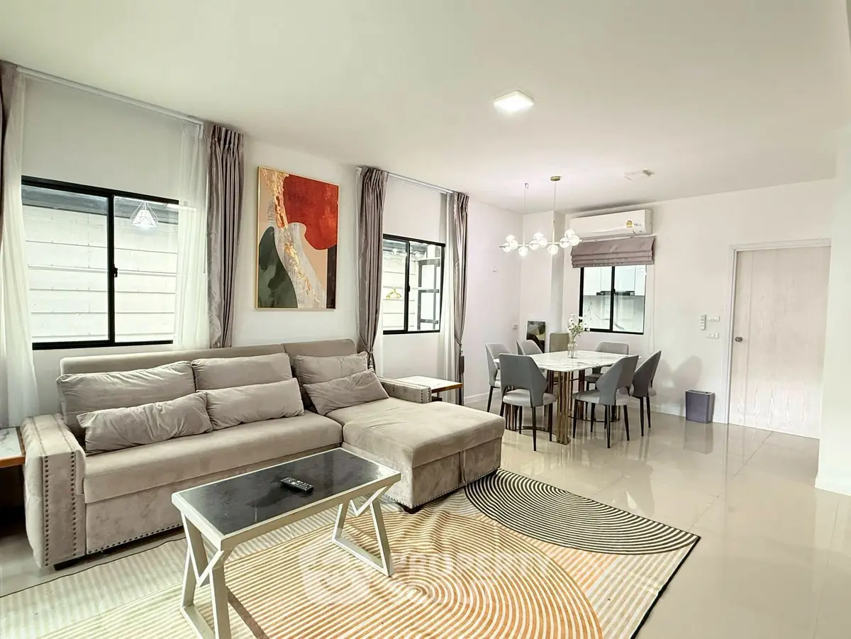 Spacious modern living room with elegant decor and dining area, featuring plush sofa and stylish lighting.