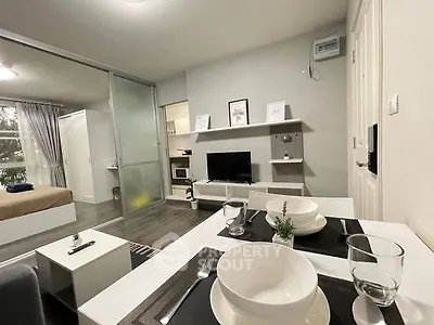 Modern open-plan living room with dining area and bedroom in cozy apartment.