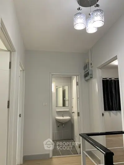Modern hallway with stylish lighting and view into a sleek bathroom