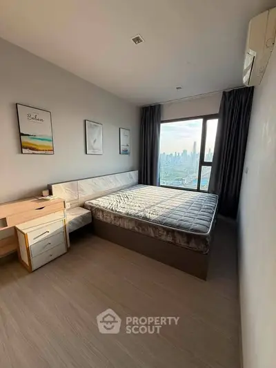 Modern bedroom with city view, featuring a large window, stylish decor, and ample natural light.