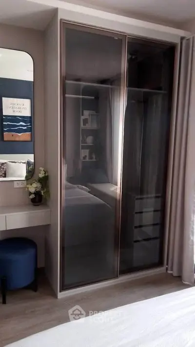 Modern bedroom with sleek glass wardrobe and stylish decor
