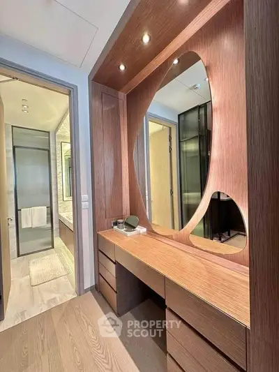 Luxurious modern bathroom with elegant wooden vanity and unique mirror design.