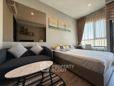 Modern bedroom with stylish decor and large window offering natural light