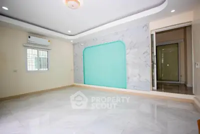 Spacious modern living room with elegant marble accents and recessed lighting.