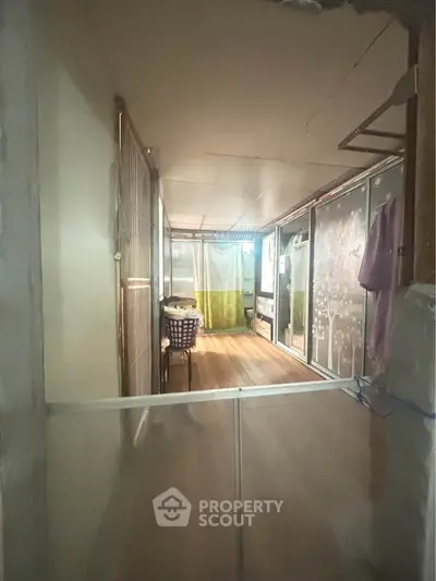 Cozy interior space with wooden flooring and laundry area, ideal for compact living solutions.