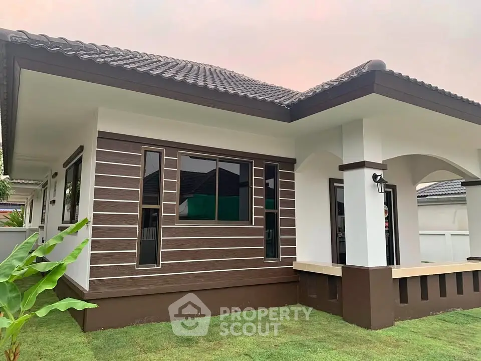 Charming single-story home with modern facade and lush green lawn