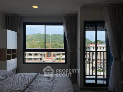 Spacious bedroom with scenic view and balcony access in modern apartment