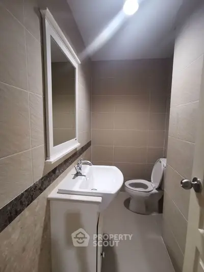 Compact modern bathroom with sleek fixtures and neutral tiles