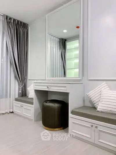 Elegant bedroom corner with mirror and seating, perfect for relaxation.