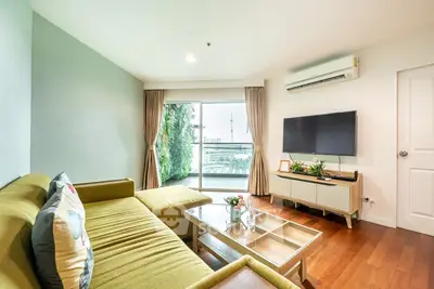 Spacious living room with modern decor and large window offering natural light.