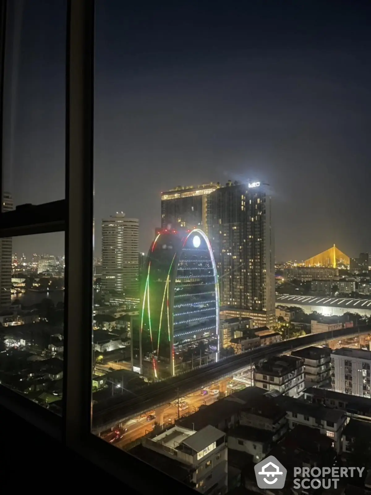 Stunning night cityscape view from high-rise window showcasing illuminated skyline and modern architecture.