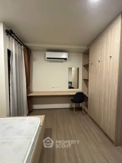 Modern bedroom with built-in wardrobe and air conditioning, featuring sleek wooden flooring and minimalist design.