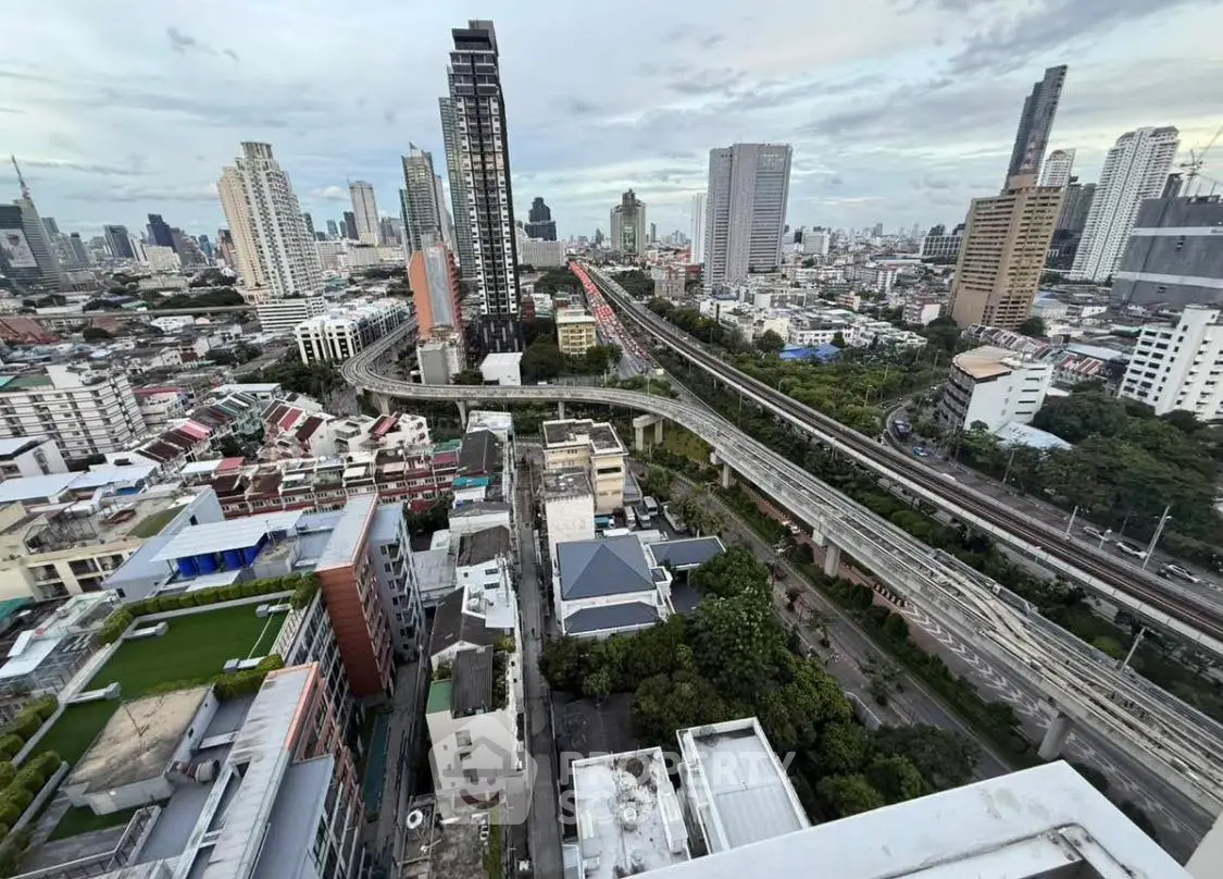 Stunning cityscape view from high-rise building with lush greenery and urban skyline.