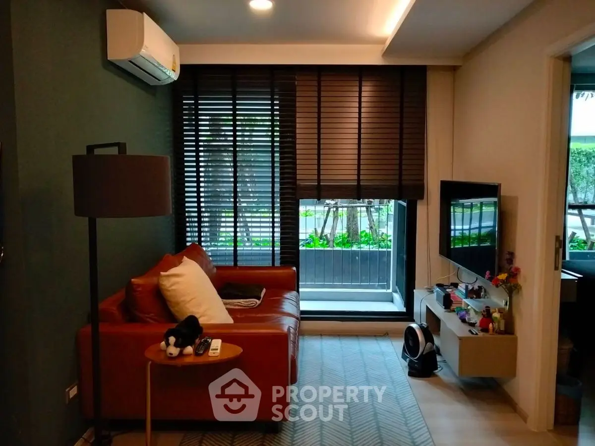 Stylish living room with modern decor and large window view.