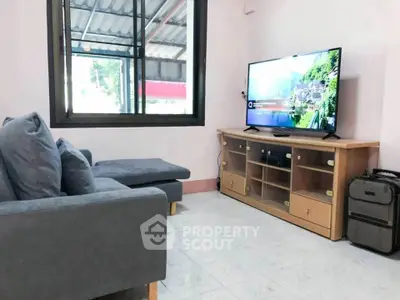 Cozy living room with modern TV setup and comfortable seating, perfect for relaxation.