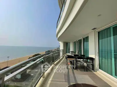 Luxurious beachfront balcony with stunning ocean view and modern outdoor furniture.