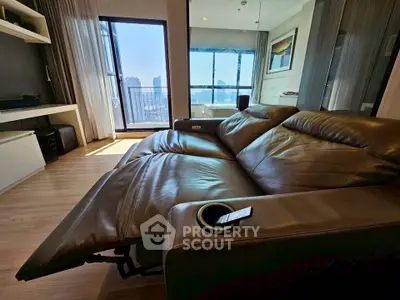 Luxurious living room with leather recliner and stunning city view from balcony.