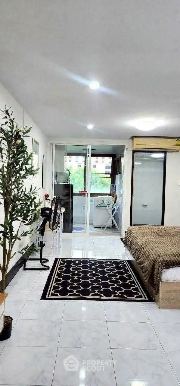 Spacious studio apartment with modern decor and large windows for natural light.