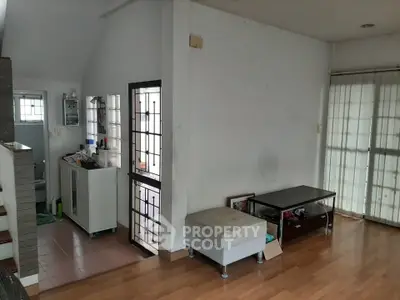 Spacious living area with wooden flooring and natural light