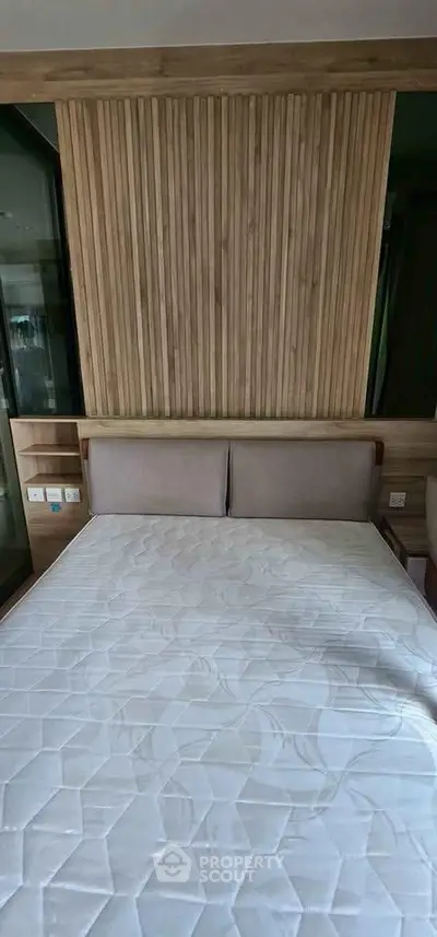 Modern bedroom with stylish wooden paneling and comfortable bed