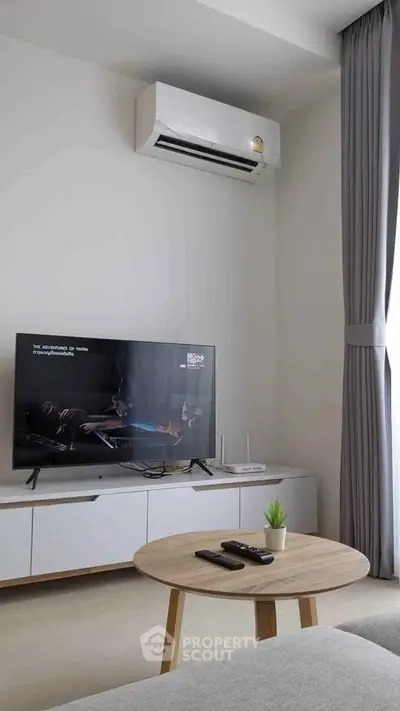 Modern living room with sleek TV setup and air conditioning, perfect for relaxation.