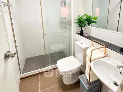 Modern bathroom with glass shower, sleek fixtures, and stylish decor.