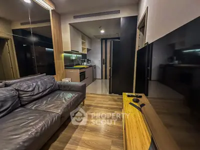 Modern living room with sleek kitchen and cozy leather sofa