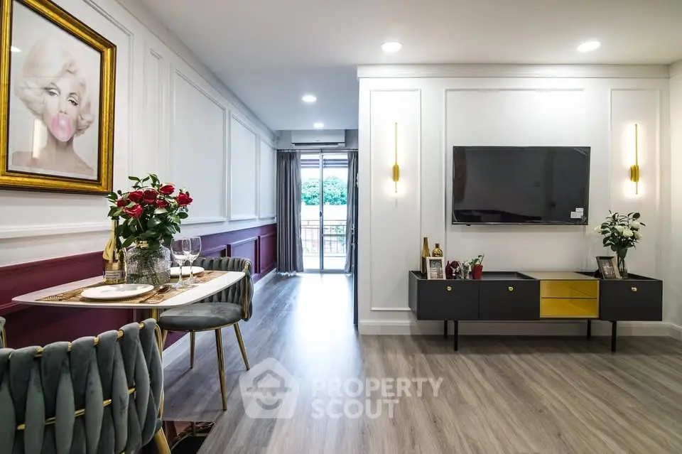 Stylish living room with modern decor and balcony view, featuring elegant dining setup and wall art.