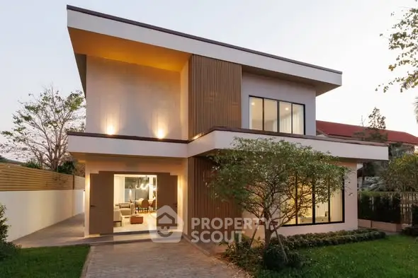 Modern two-story house with large windows and stylish exterior lighting.