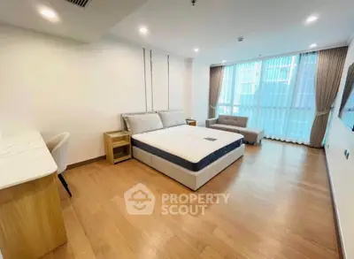 Spacious modern bedroom with large windows and elegant furnishings in a luxury apartment.