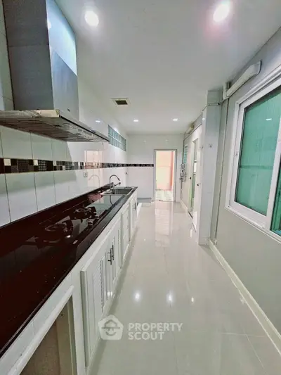Sleek modern kitchen with glossy countertops and ample storage space.
