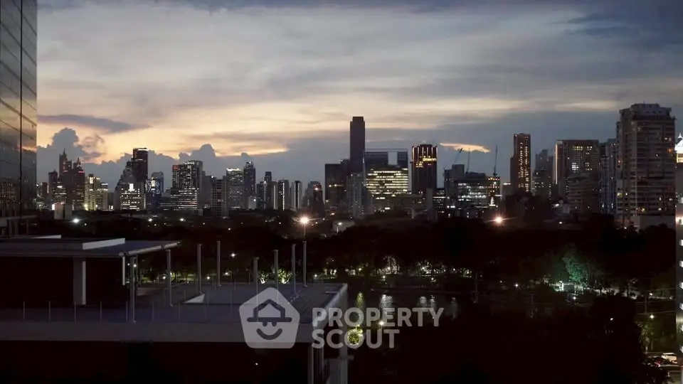 Stunning city skyline view at dusk with illuminated skyscrapers and serene park setting.
