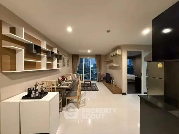 Modern open-plan living and dining area with stylish shelving and balcony view.