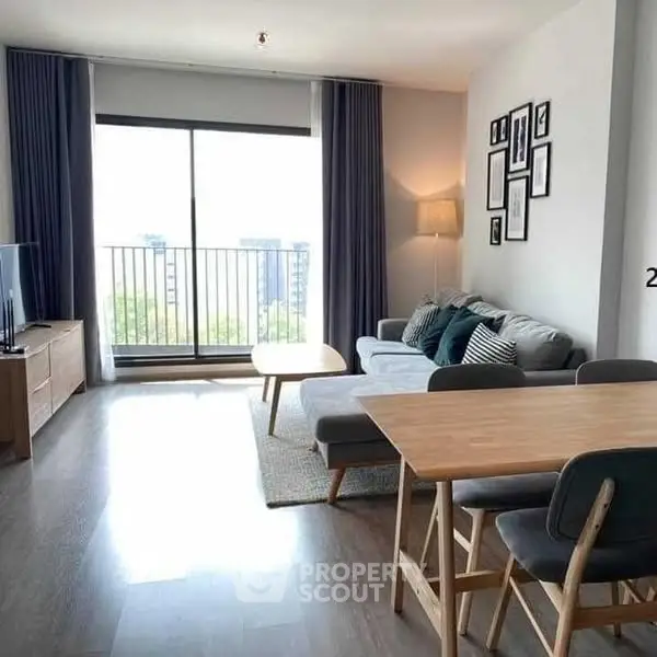 Modern living room with balcony view, stylish furniture, and ample natural light.