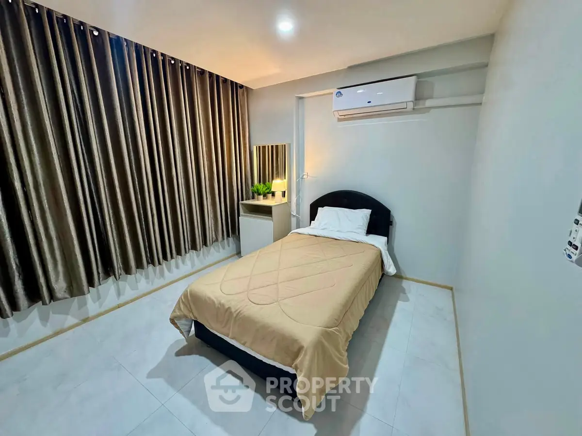 Cozy bedroom with modern air conditioning and elegant curtains, perfect for a restful night's sleep.