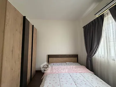 Cozy bedroom with modern wardrobe and large window with curtains, perfect for relaxation.